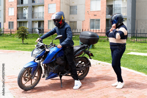 Photography People wearing helmets preparing to ride a motorcycle on an urban street