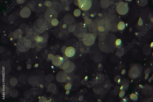 Defocused bokeh lights in various sizes and colors on a dark background creating a dreamy and abstract visual effect