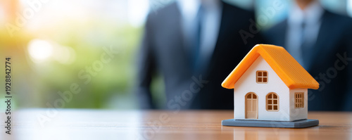 Real estate house property investment mortgage business contract insurance Modern miniature house model wooden table with blurred business people