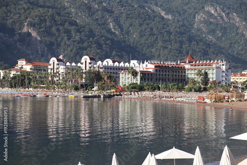 Wallpaper Mural Hotel complex reflecting on calm water at the foot of green mountains Torontodigital.ca