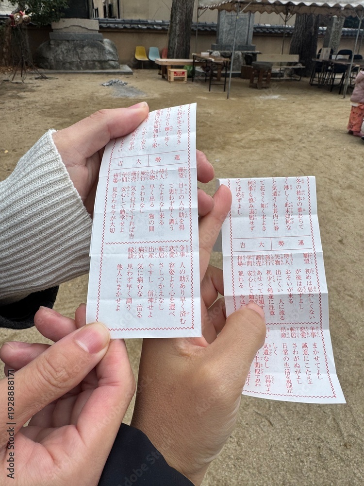 Naklejka premium 日本の神社で正月におみくじをひく二人の様子