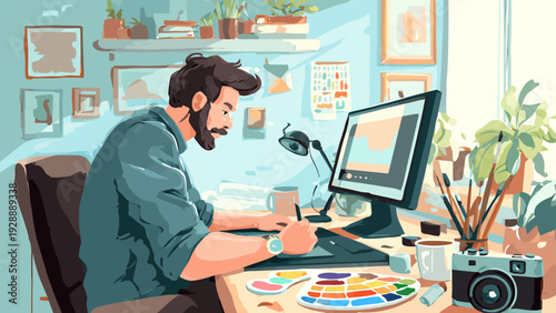 Young freelance graphic designer working at desk with computer and design tools in a creative office environment viewed from the side