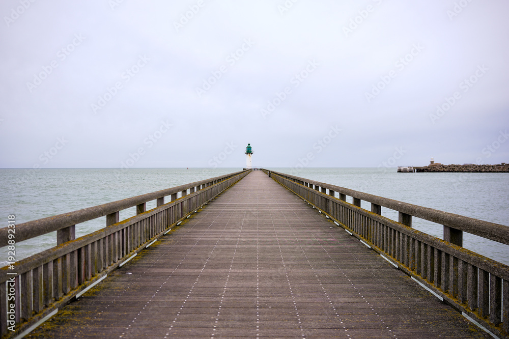 Fototapeta premium Long pier reaching lighthouse over calm sea Calais France