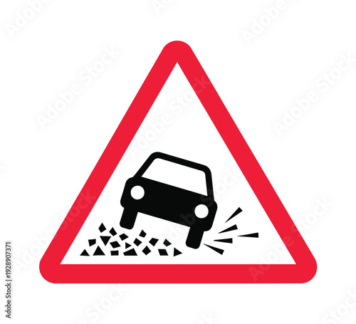 A warning sign indicating loose chippings or gravel on the road ahead, advising caution for drivers.