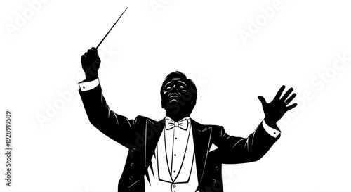 A conductor leads an orchestra with a baton in his right hand and gestures with his left in a tuxedo on stage