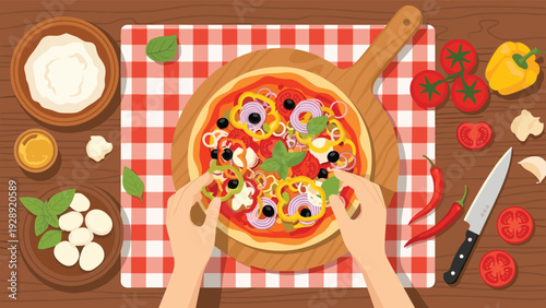 Top-down view of hands adding fresh vegetable toppings to a colorful pizza on a wooden board with ingredients nearby.