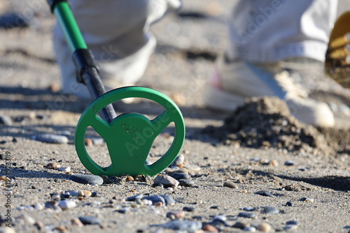 Metal detector search. Beach metal detecting. A metal detector in hand in nature, a seascape during the cold season. High quality photo
