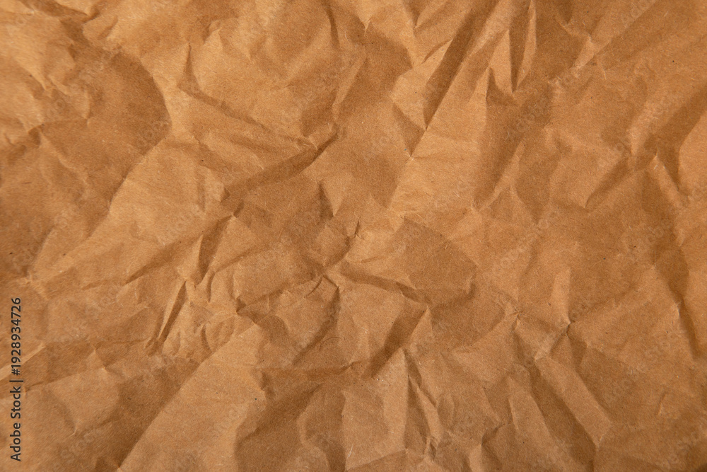 Obraz premium Creased wrap paper glow brown tone color texture background with space 