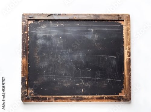 A dark and weathered vintage chalkboard rests against a textured grunge concrete wall, featuring an aged black surface with a dusty pattern of chalk and a blank wooden frame