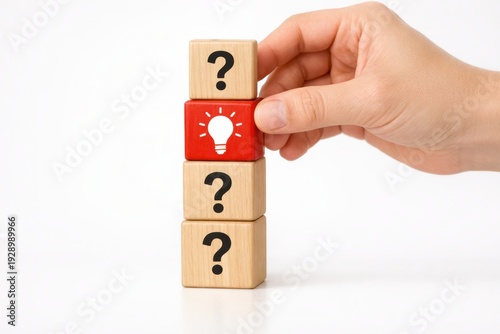 Idea Unveiled: A hand meticulously places a red block bearing a lightbulb icon atop a stack of question mark-adorned blocks, symbolizing the revelation of an innovative idea.