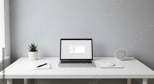 Minimalist desk setup with open laptop, notebook, and plant for modern remote work.