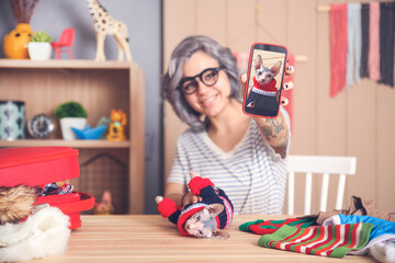Woman showing cell phone picture of Sphynx cat wearing pullover
