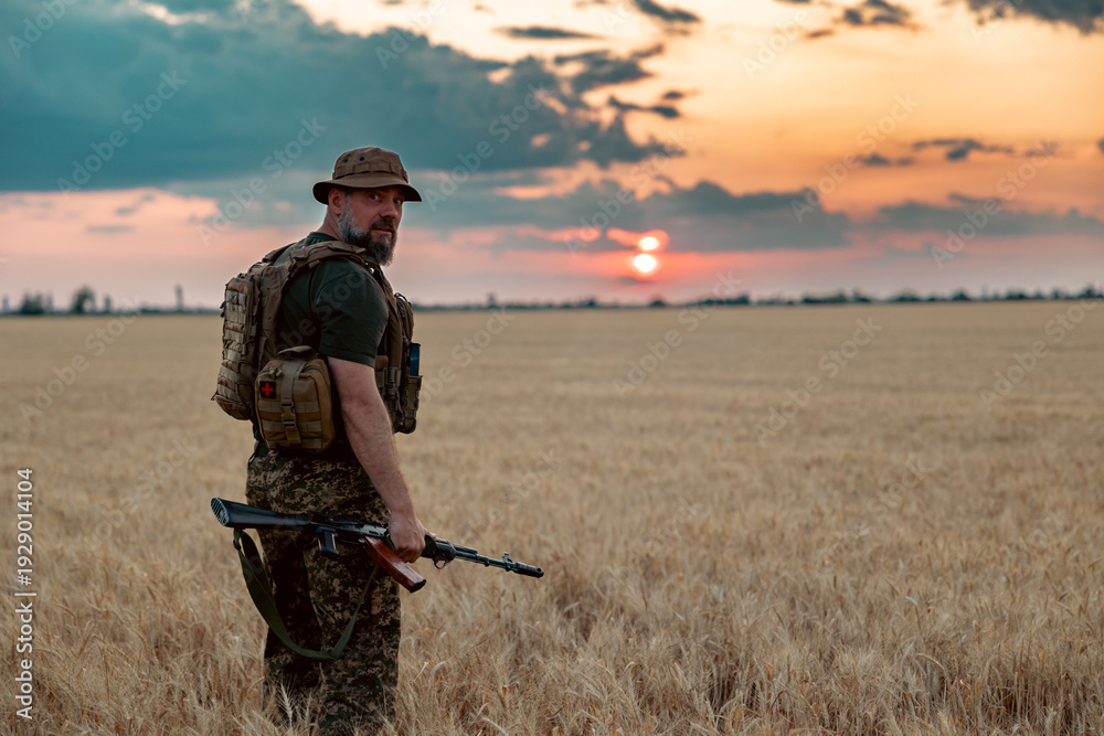 Fototapeta premium Soldier with a rifle in the field