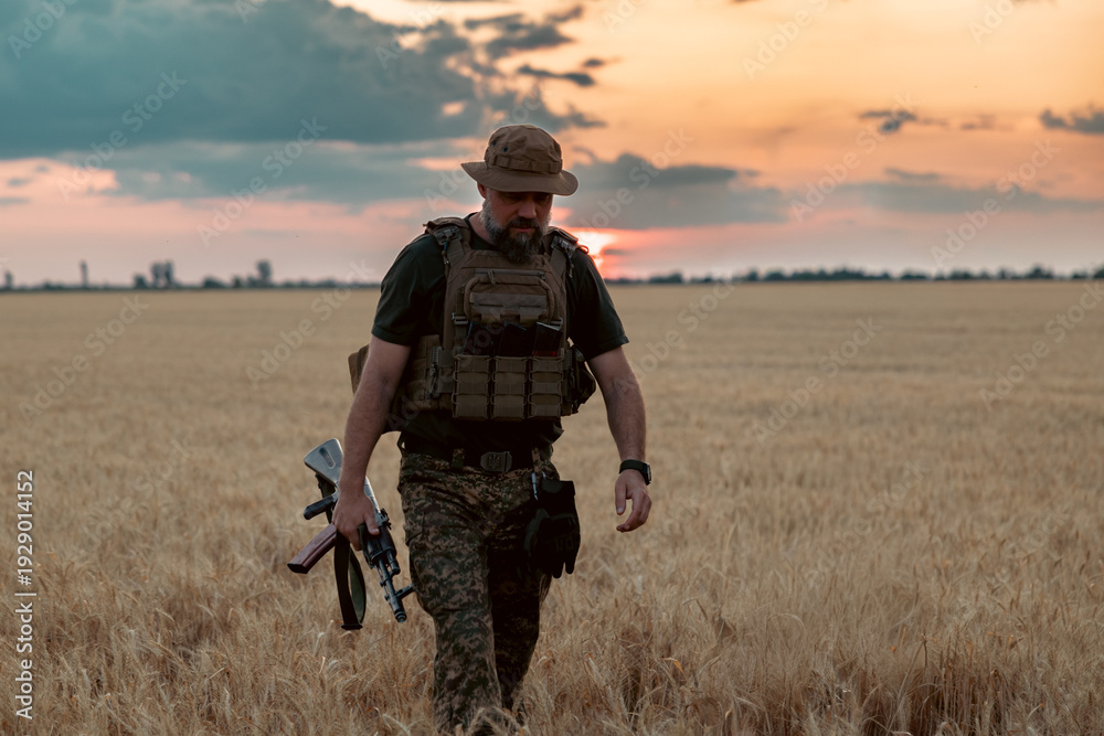 Fototapeta premium Soldier with a rifle in the field