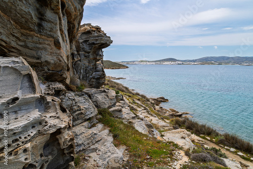 Rocky, hilly and lush landscape at the Paros Park and the Aegean Sea on Paros island in Greece on a sunny day.