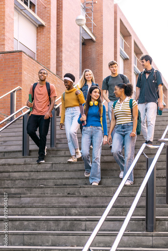 Diverse group of young students walking down urban university stairs together, enjoying college life and education