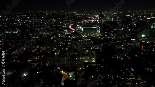 Los Angeles skyline at night with highway traffic aerial view. 