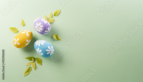 Easter party concept. Top view of easter bunny ears and colorful eggs on pastel background with copyspace for the text.
