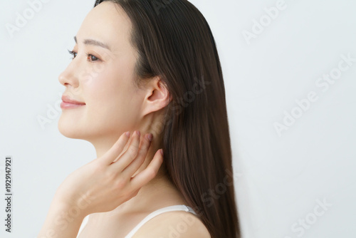 фотографія ロングヘアの髪の毛に手を触れる若い日本人女性　ビューティ