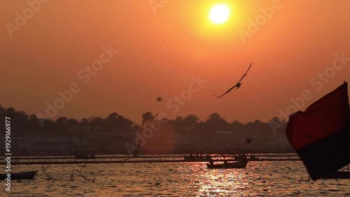 Orange Sunset with Boats and Birds over River Ganga in Prayagraj.