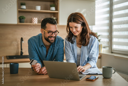 Bilde på lerret Young couple managing household finances and online shopping together