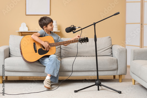 Cute boy playing guitar on ...