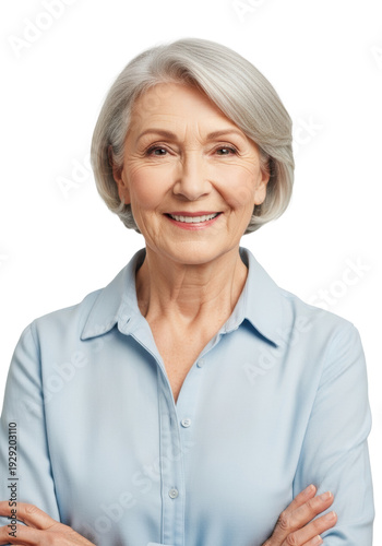 elegant elderly caucasian woman (70s), short grey hair, warm smile, pastel blue shirt, arms crossed. high-key studio portrait against white background with copy space. concept of senior confidence