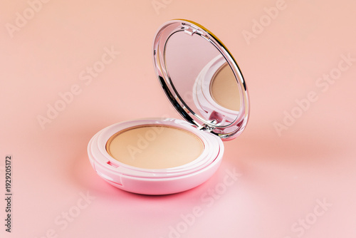 Pastel pink compact Powder, face powder or powder makeup whit blush contour, isolated object on pink background 