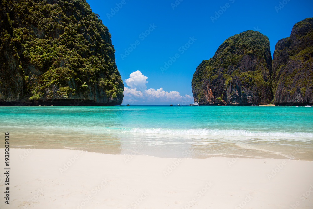 Fototapeta premium Panorama of Maya Bay on Koh Phi Phi Leh, Thailand. It's a famous white sand beach with a crystal-clear turquoise waters. A pristine and tropical shoreline enclosed by towering limestone karst cliffs.