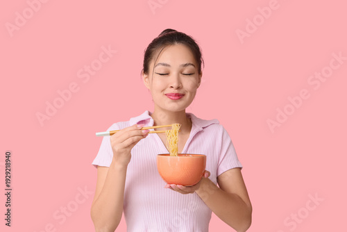 Young Asian woman eating ta...