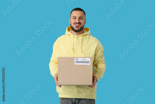 Young man with parcel on bl...