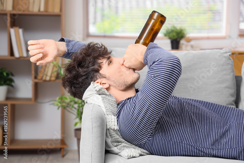 Young man drinking beer whi...
