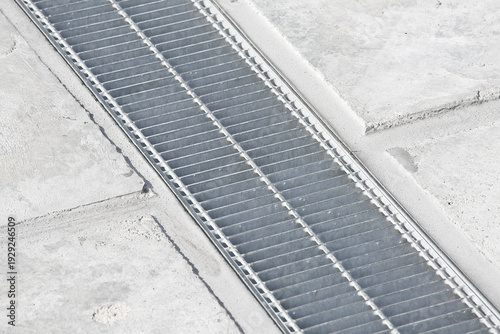 Obraz na plátne GALVANIZED INDUSTRIAL STEEL RAINWATER COLLECTION GRATE in a parking lot with con