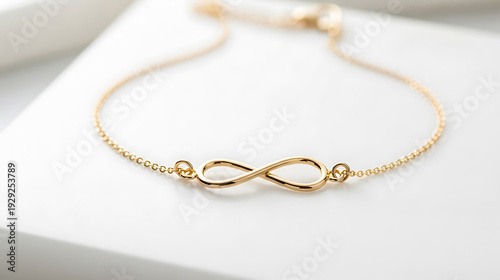 Elegant gold infinity bracelet on white background, symbolizing eternal love and connection