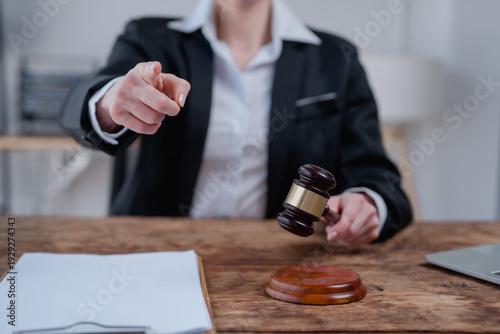 Foto Judge or lawyer pointing a finger forward while holding a gavel, symbolizing jus