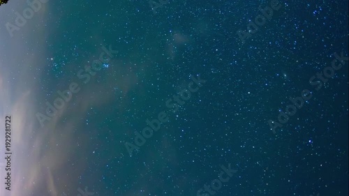 Dramatic 4K night time-lapse showing the movement of stars and Milky Way over a grove of trees and scenic mountain panorama, southern Europe.

