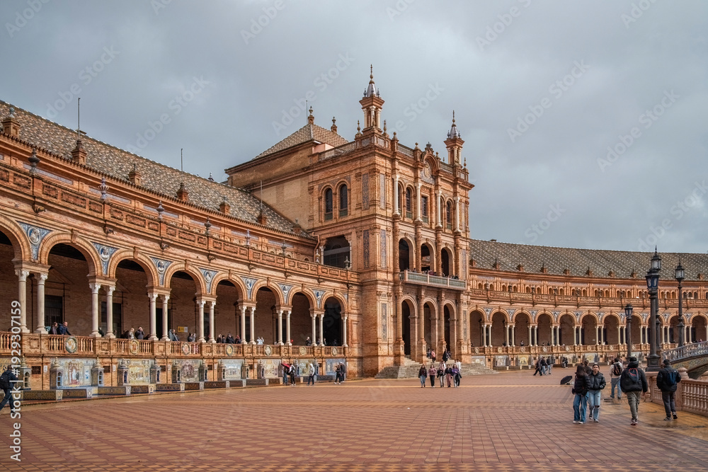 Fototapeta premium Plaza de Espana, Sivilla. Historic stone building with towers and courtyard under cloudy sky