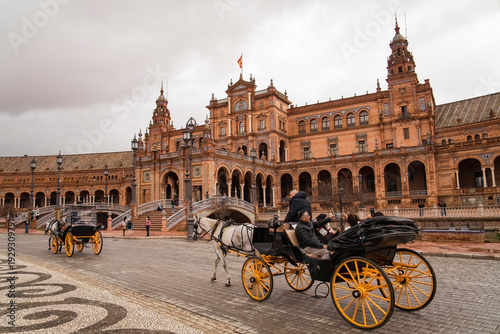 Plaza de Espana, Sivilla. Historic stone building with towers and courtyard under cloudy sky