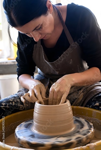 Focused Female Potter at Work on Spinning Wheel in Studio