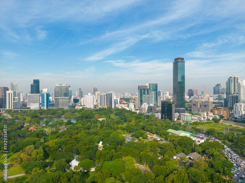 Fototapeta premium Aerial view modern office building with green tropical Lumpini park forest blue sky business travel background Bangkok Thailand