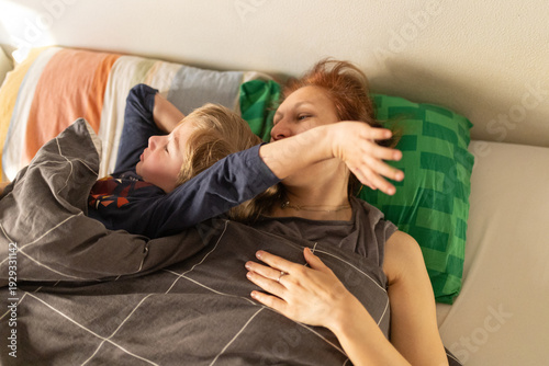 Canvastavla Mother and son relaxing in bed together