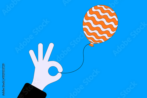Hand holding orange patterned balloon string