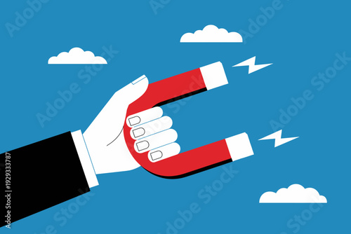 Hand holding red horseshoe magnet attracting electricity  business concept