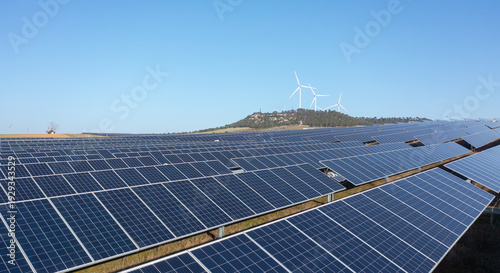 Solar Panels with Wind Turbines Under Blue Sky Renewable Energy Concept