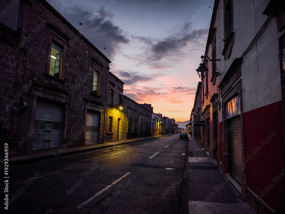 Fototapeta premium A quiet street with a few buildings and a few cars