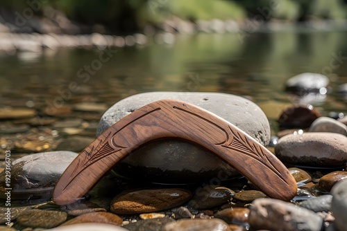 Non-Returning Hunting Boomerang on River Stones Near Clear Water