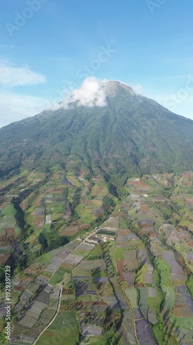 Aerial View of Mountain Terraced Farmland and Reservoir Near Village on a Clear Sunny Day