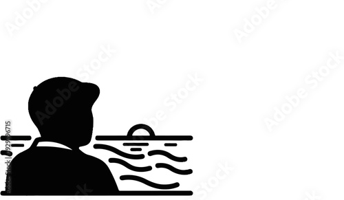 Silhouette of a man gazing at a sunset over the ocean waves