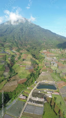 Aerial View of Mountain Terraced Farmland and Reservoir Near Village on a Clear Sunny Day