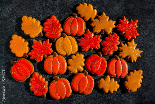 Yellow and orange autumn gingerbread cookies in the shape of pumpkins, maple leaves, and oak leaves